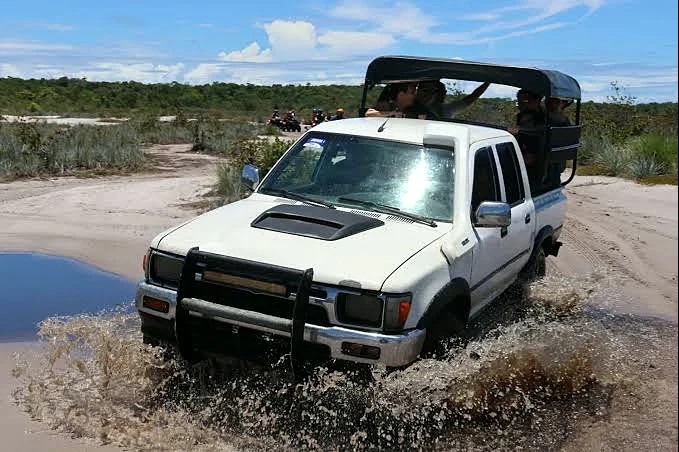 Veículo 4x4 atravessando trecho alagado no caminho para Garapuá
